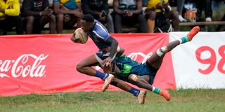 Brunson Madigu (left) of Strathmore Leos charges past KCB's Alex Mulwa