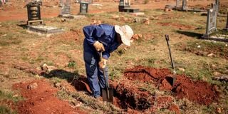 An Avalon Cemetery worker digs a grave in the graveyard section at the Avalon Cemetery in Soweto
