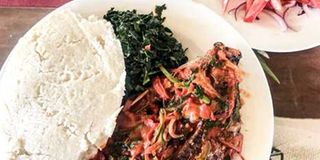 A meal of ugali, sukumawiki and fish.