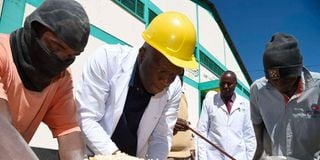 Trade Principal Secretary, Fred Ombudo K’Ombudo second (left), samples maize delivered to NCPB Eldoret depot