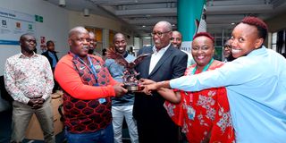 NMG Sports ME Elias Makori receives trophy from CEO Stephen Gitagama