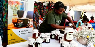 Ms Soin Chebet of Soin Honey arranges jars of honey sourced from Baringo County during the Nation Media Group SMEs Conference
