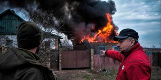 Residents near a burning building after shelling in Kostyantynivka, Donetsk region