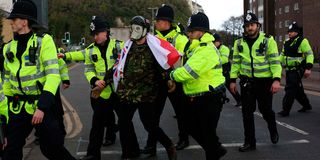 A demonstrator is temporarily detained by police during an anti-immigration protest march in Dover