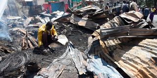 A man ravages through the debris of what used to be stalls near Karanja road in Kibera