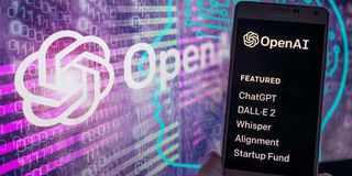 The OpenAI logo on screen with ChatGPT website