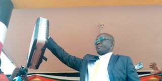 West Pokot Governor Simon Kachapin displays a flag and county seal at his swearing in ceremony on August 25, 2022.