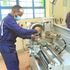 A mechanical engineering student operates a lathe machine at Nyeri National Polytechnic