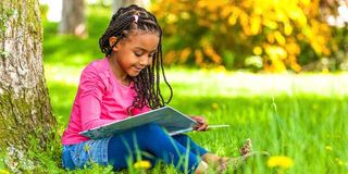 A girl reading under a tree