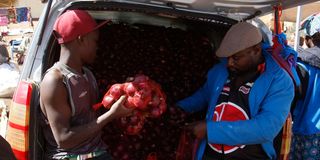Traders sort out onions from a car parked by the roadside in Elburgon, Nakuru County