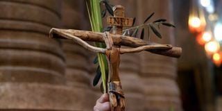 A Catholic pilgrim holds up a crucifix and a palm branch during the Palm Sunday procession in Jerusalem.