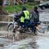 A boda boda operator manoeuvres through a flooded street in Nakuru city