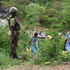 A policeman watches over pupils of Kapindasum Primary School in Baringo South Constituency, Baringo County as they fetch water 