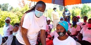 Save the Teenage Girl Initiative Founder Peris Wangari (left) presents gift hampers to girls 