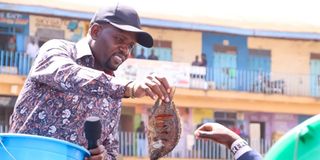 Trans Nzoia Governor George Natembeya buying fish from a trader in Kitale town