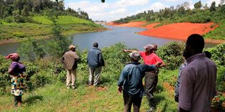 Some of the residents of Githang’a village in Kiambu County look at a section of Karimenu II Dam