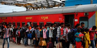 Passengers queue along a platform to board the Chennai bound Coromandel Express at Shalimar station