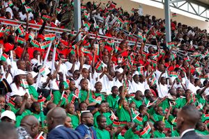 School children wave Kenyan flags during the 60th Madaraka Day celebrations at Moi Stadium in Embu