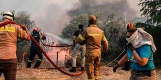 Firemen attempt to extinguish a fire in Nea Anchialo, Greece