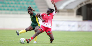 Harambee Starlets' Teresha Engesha (right) vies for the ball with Cameroon Lionesses' Mayi d