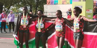 Team Kenya celebrate with the flag after women's half marathon race