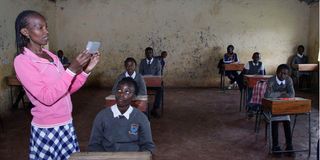 An invigilator inspects the Standard Eight candidates at Rosebuds School in Elburgon