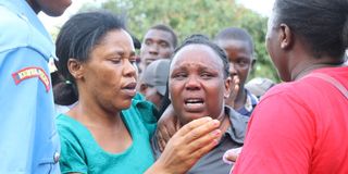 A mother is comforted after identifying the body of her son