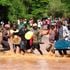 Swimmers help a student cross River Muooni in Kavuthu township