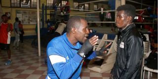 Le capitaine de l'équipe de boxe du Kenya, Nick Abaka (à gauche), donne des conseils au boxeur poids mouche Brian Agina. 