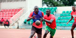 Kevin Imo (left) charges past teammate Nicholas Kiremi 
