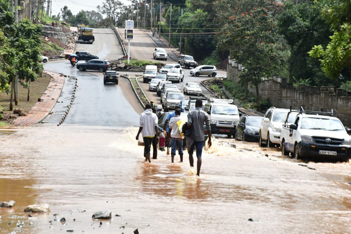 Cars and pedestrians wade through flooded roads on UN Avenue Gigiri