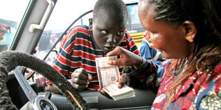 A motorist changes money from a boy in Juba, South Sudan